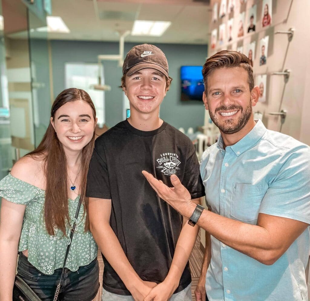 Smiles with Dr. Rucker | Rucker Orthodontics Dr. Rucker smiling with two young people in the orthodontic office.